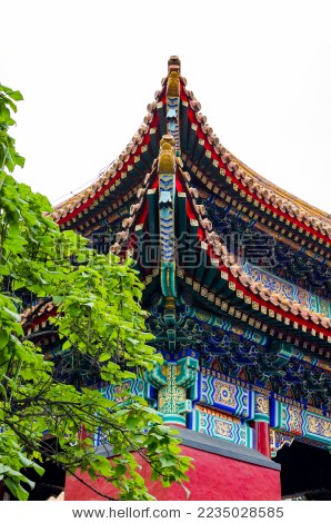 中国北京雍和宫古代建筑房顶红墙飞檐绿叶图片
