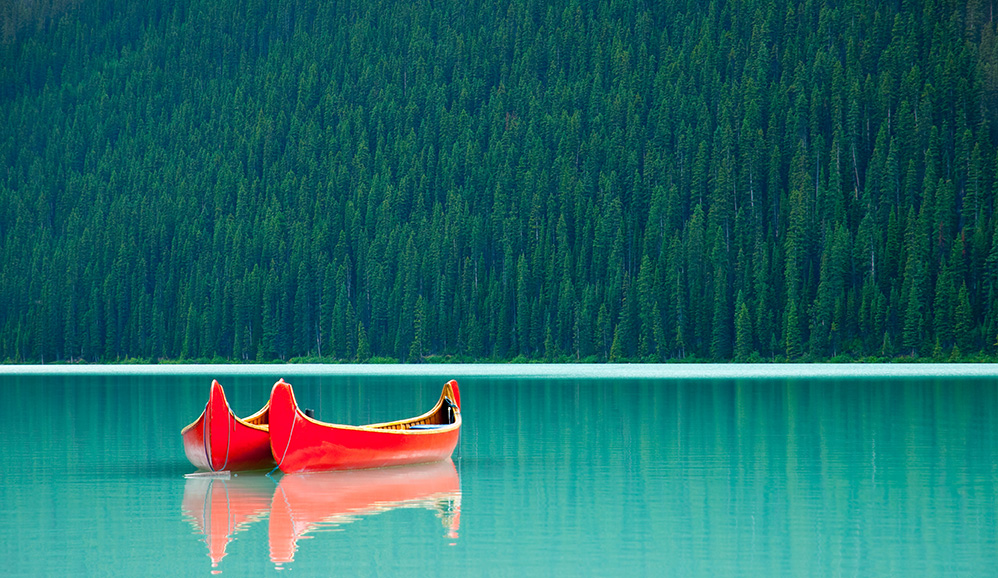 Canoes floating peacefully on the waters of Lake Louise, Banff National Park, Alberta, Canada by Darren J. Bradley